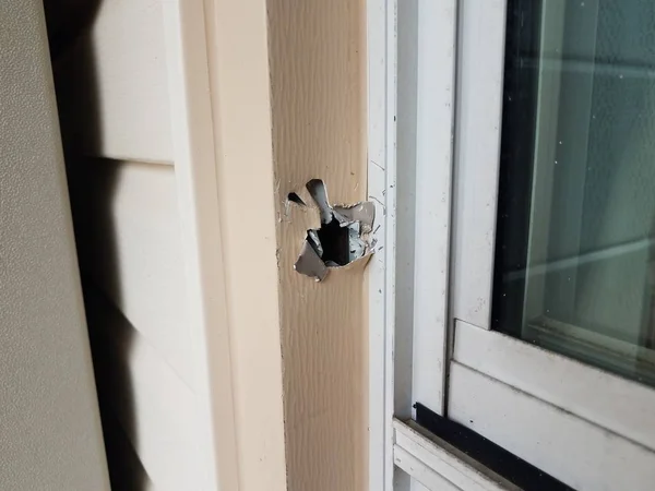 Foro in telaio metallico danneggiato di finestra su casa — Foto Stock