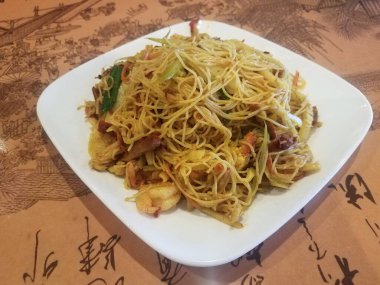 spicy chinese noodles with meat on plate on table