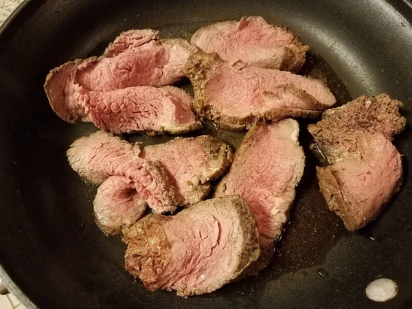 Roast beef meat cooking in frying pan on stove — 图库照片