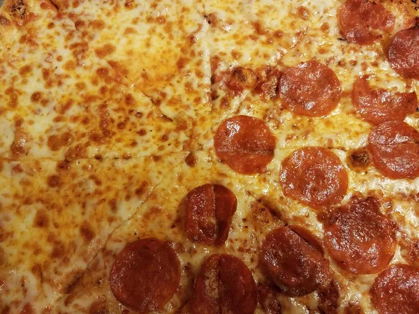 Half cheese half pepperoni cheesy pizza slices — Stock fotografie