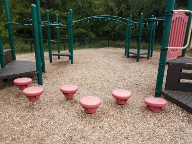 play structure with green bars and red stepping stones