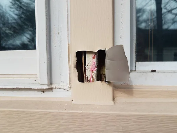 Hole or damage in metal window frame — Stock fotografie