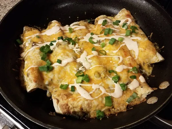Enchiladas with cheese and onions and sauce in frying pan — Stok fotoğraf