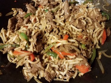 noodles and beef and peppers in frying pan