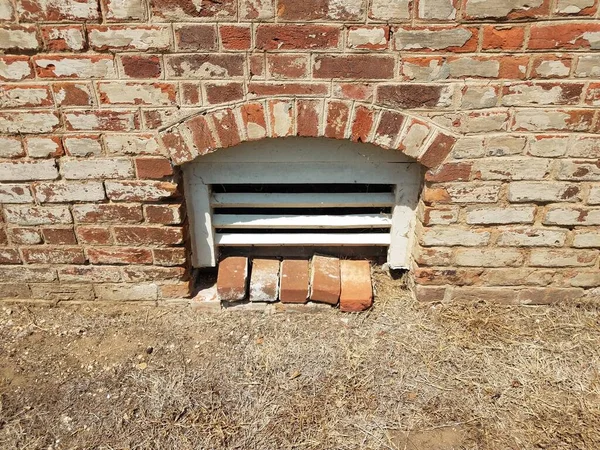 Basement window with red bricks and brown grass — Foto de Stock