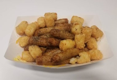 sausage and tater tots in container with salt and pepper