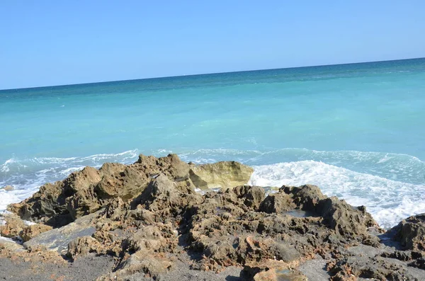 Sand and rocks and ocean water at beach — Stockfoto