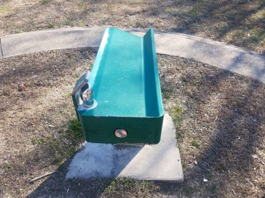 green water fountain in park with grass