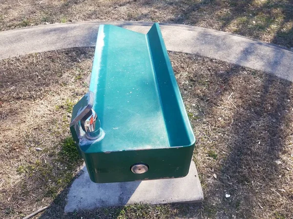 Green water fountain in park with grass — Stok fotoğraf