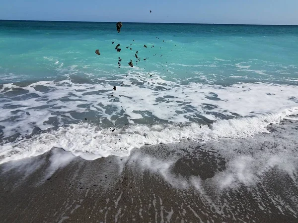 Sand am Strand mit Meereswellen in die Luft geworfen — Stockfoto
