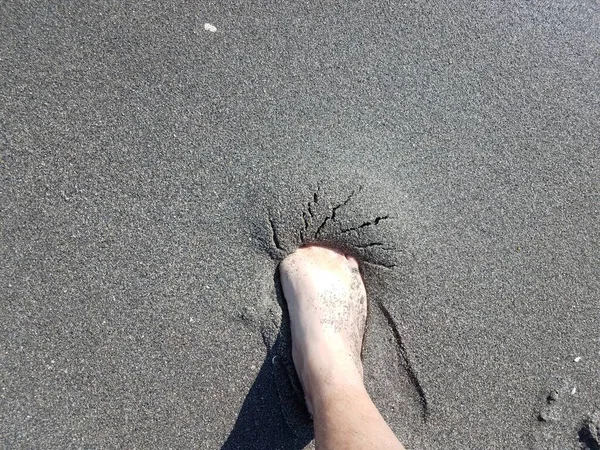 Pie masculino en arena húmeda gris en la playa —  Fotos de Stock