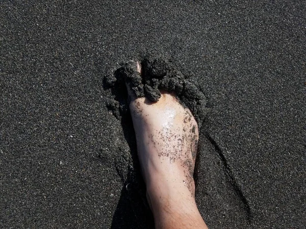 Pie masculino en arena húmeda gris en la playa — Foto de Stock