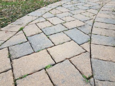 Pembe ve gri taştan otlu döşeme yolu