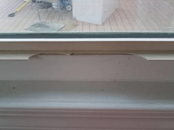 Scharfes zerbrochenes oder beschädigtes Kunststoffstück an altem Fenster — Stockfoto