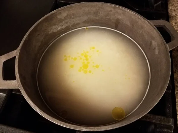Oil and murky water in metal pot on stove — Φωτογραφία Αρχείου