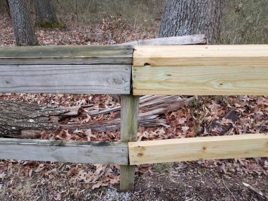 railing with old and new wood and brown leaves