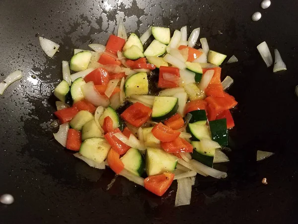 Red peppers and onions and zucchini cooking in pan — Stok fotoğraf