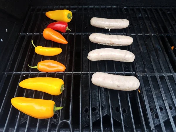 Sausages and colorful peppers on barbecue grill — Stockfoto