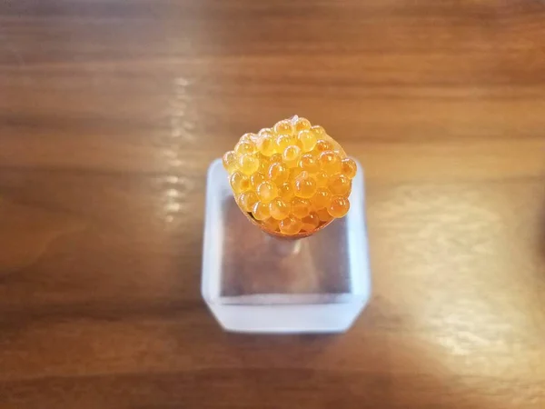 Оранжевые яйца в конусе и держатель на деревянном столе — стоковое фото