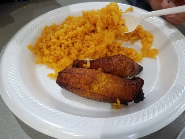 Banana de bananeira e arroz amarelo em prato branco — Fotografia de Stock