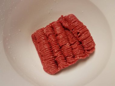 Beyaz kabın içinde çiğ et.