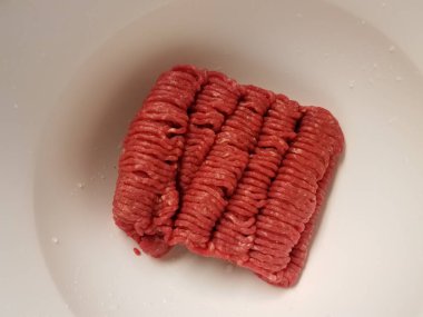 Beyaz kabın içinde çiğ et.