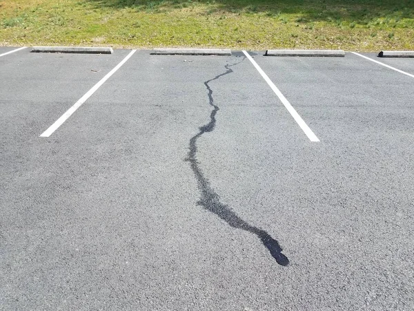 Derramamento de líquido no pavimento preto no espaço de estacionamento — Fotografia de Stock