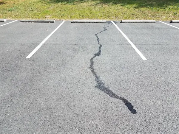 Derramamento de líquido no pavimento preto no espaço de estacionamento — Fotografia de Stock