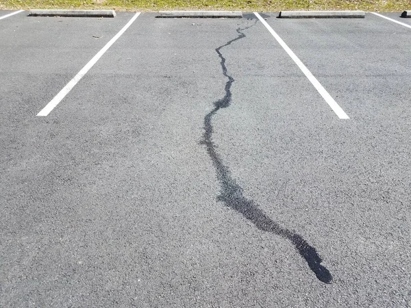 Derramamento de líquido no pavimento preto no espaço de estacionamento — Fotografia de Stock