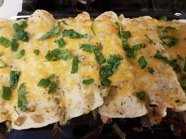 Enchiladas al horno con queso y cilantro en bandeja de vidrio sobre estufa —  Fotos de Stock