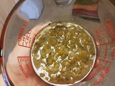 Elinizde yeşil salsa soslu ölçü kabı var.