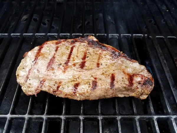 Barbekü ızgarasında pişirilmiş biftek ve sıvı. — Stok fotoğraf