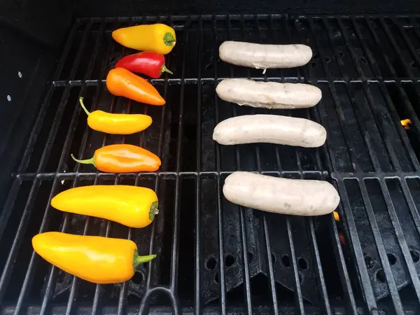 Korv och färgrik paprika grillning på grill — Stockfoto