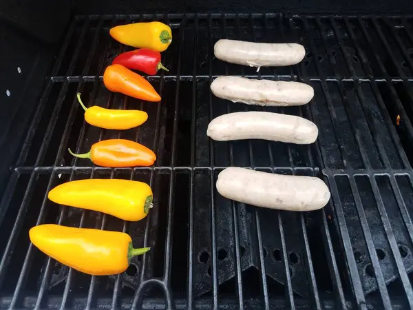Saucisses et poivrons colorés grillades sur barbecue — Photo