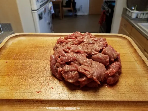 Nyers marhahús fa vágódeszkán a konyhában — Stock Fotó