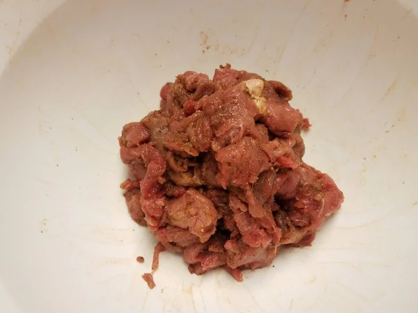Carne crua temperada em tigela ou recipiente branco — Fotografia de Stock