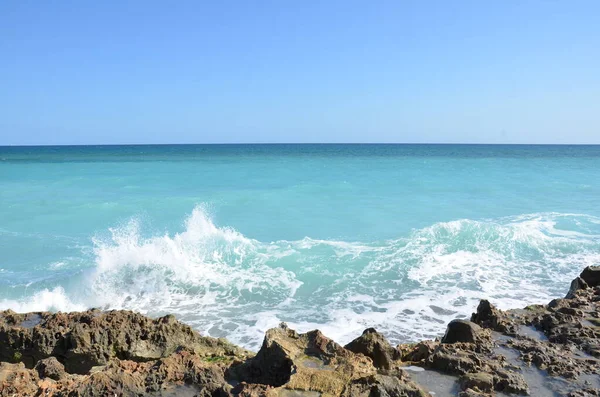 Felsen und Wasser und Wellen am Strand — Stockfoto