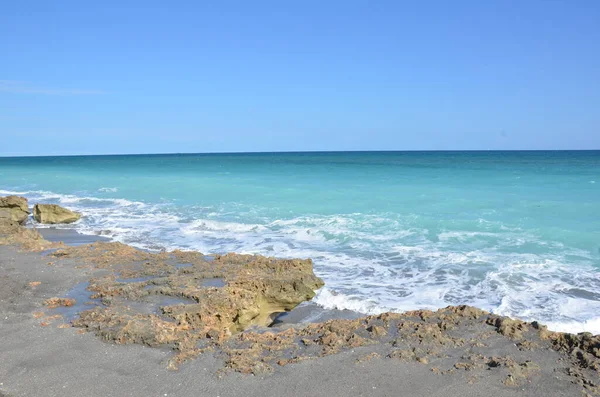 Felsen und Wasser und Wellen am Strand — Stockfoto