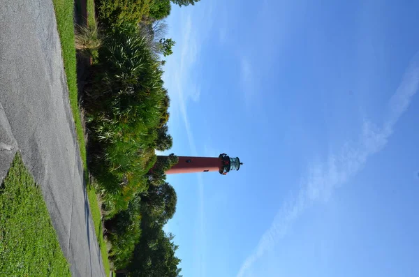 Red lighthouse with path or trail and trees — Stock Photo, Image