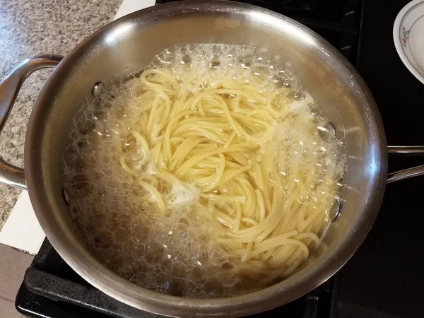 Fazék spagetti tészta forró vízben a tűzhelyen — Stock Fotó