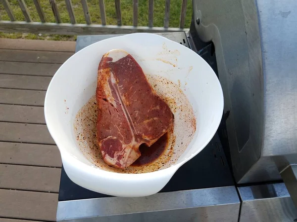 Fűszerezett nyers steak hús fehér tálban grillsütőn — Stock Fotó