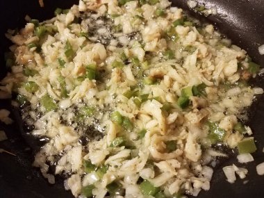 Kızartma tavasında morina, yeşil biber ve soğan.