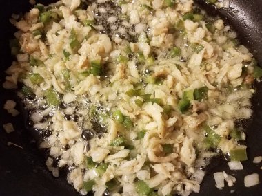 Kızartma tavasında morina, yeşil biber ve soğan.