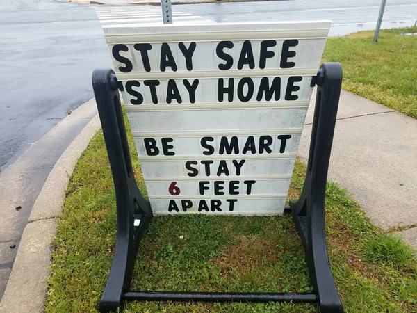 stay safe stay home stay six feet apart sign on grass near sidewalk