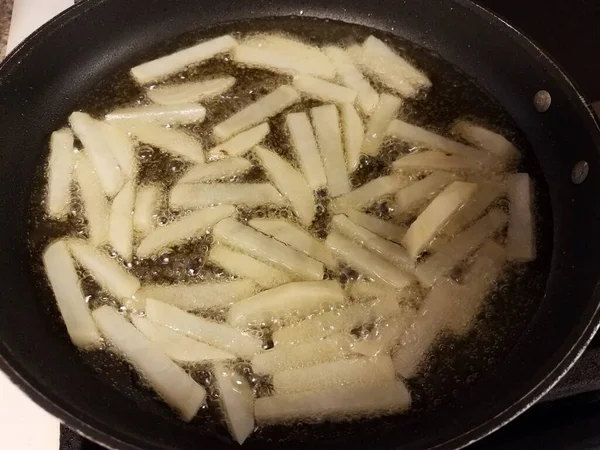 Pommes Kartoffeln in heißem Öl in der Pfanne — Stockfoto