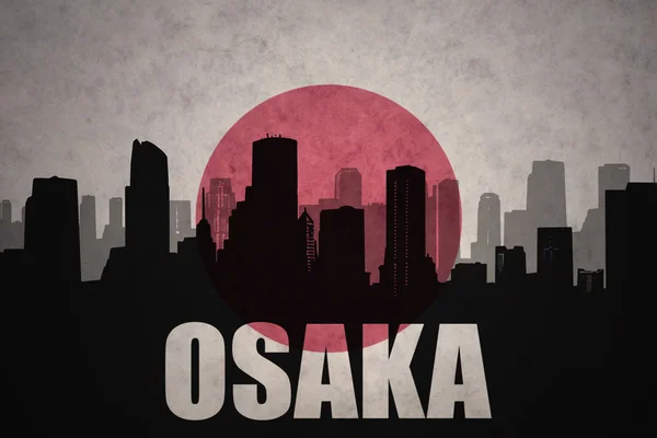 Silhueta abstrata da cidade com texto Osaka no fundo da bandeira japonesa vintage — Fotografia de Stock