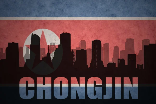 Abstract silhouet van de stad met tekst Chongjin op de Vintage Noord-Korea vlag achtergrond — Stockfoto
