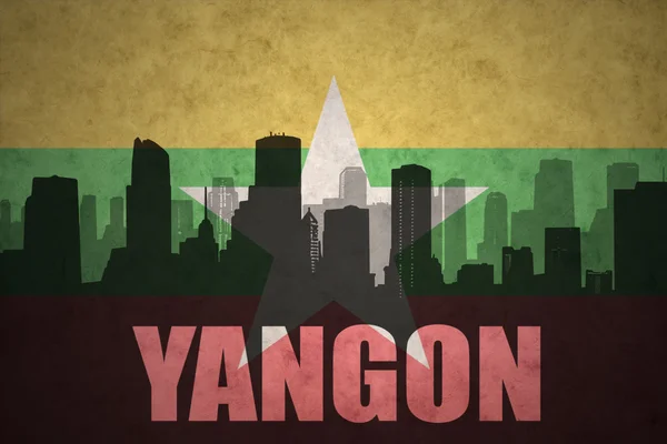 Silueta abstracta de la ciudad con texto Yangón en el fondo de la bandera de myanmar vintage — Foto de Stock