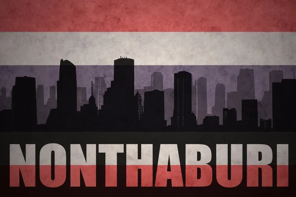 Abstrakte Silhouette der Stadt mit Text nonthaburi auf dem Hintergrund der thailändischen Flagge — Stockfoto