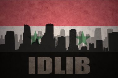 abstract silhouette of the city with text Idlib at the vintage syrian flag background clipart